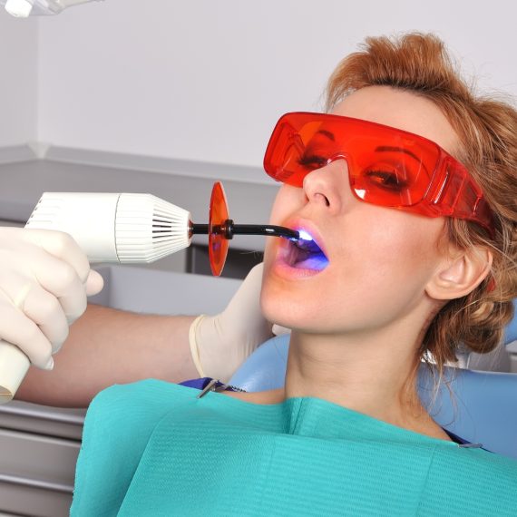 Patient with protective glasses while a filling is cured